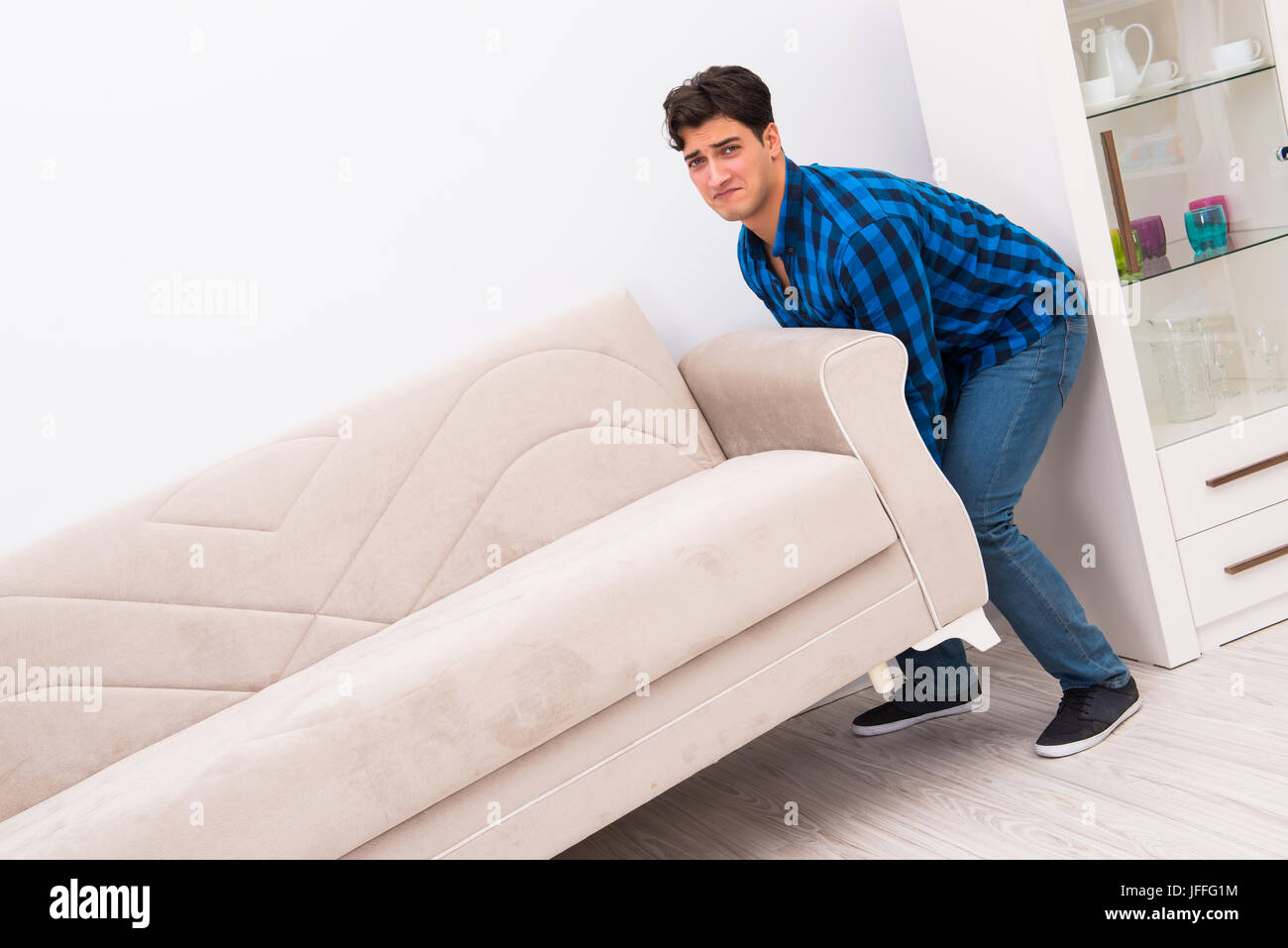Joven moviendo sofá cama Fotografía de stock - Alamy