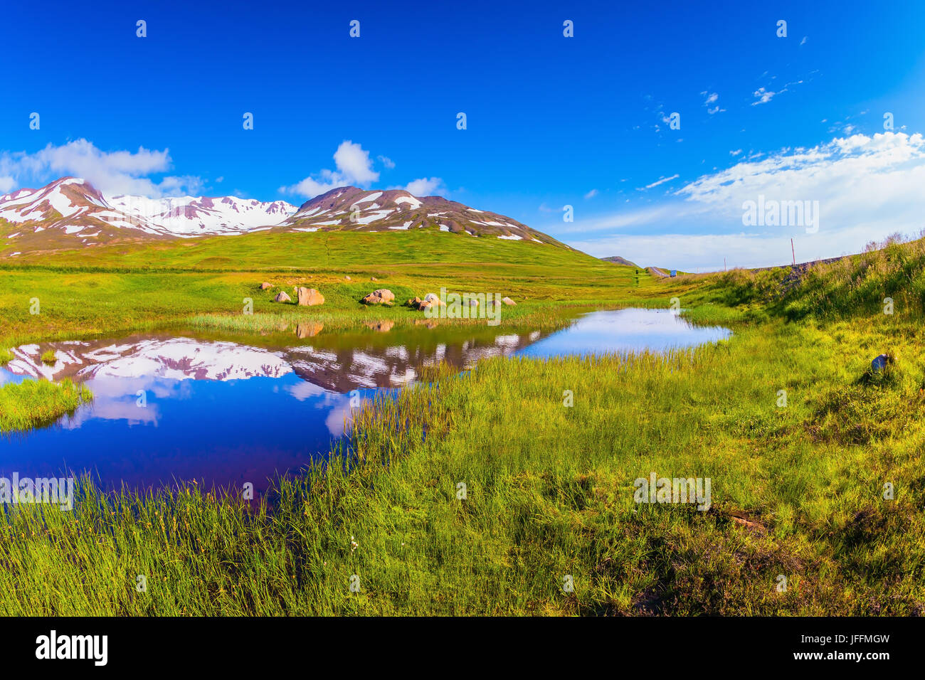 Blue Lake refleja las colinas nevadas Foto de stock