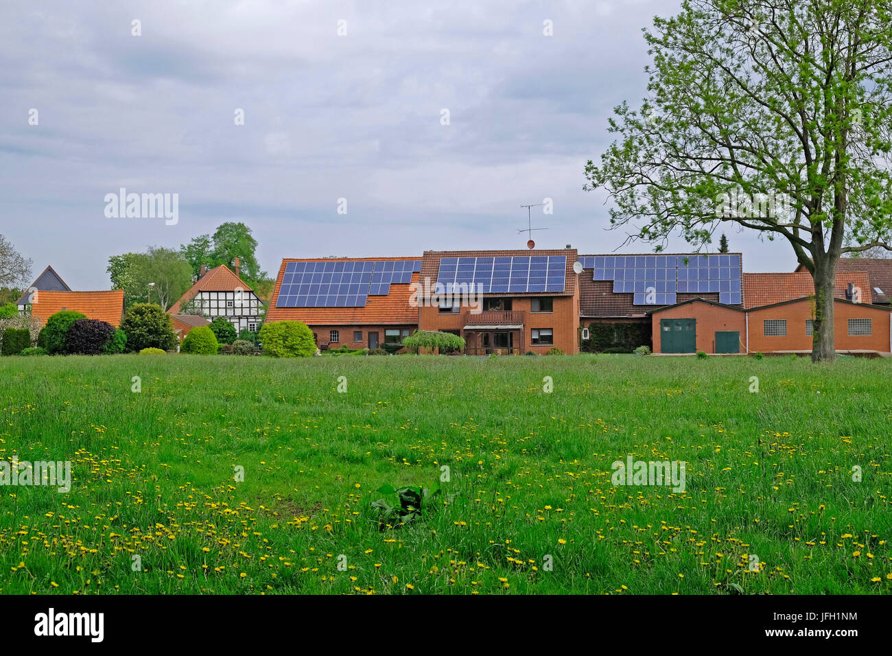 Modernos edificios de ladrillo con células solares junto a una tradicional casa de entramados en Hävern, distrito de Minden-Lübbecke, Renania del Norte-Westfalia, Alemania Foto de stock
