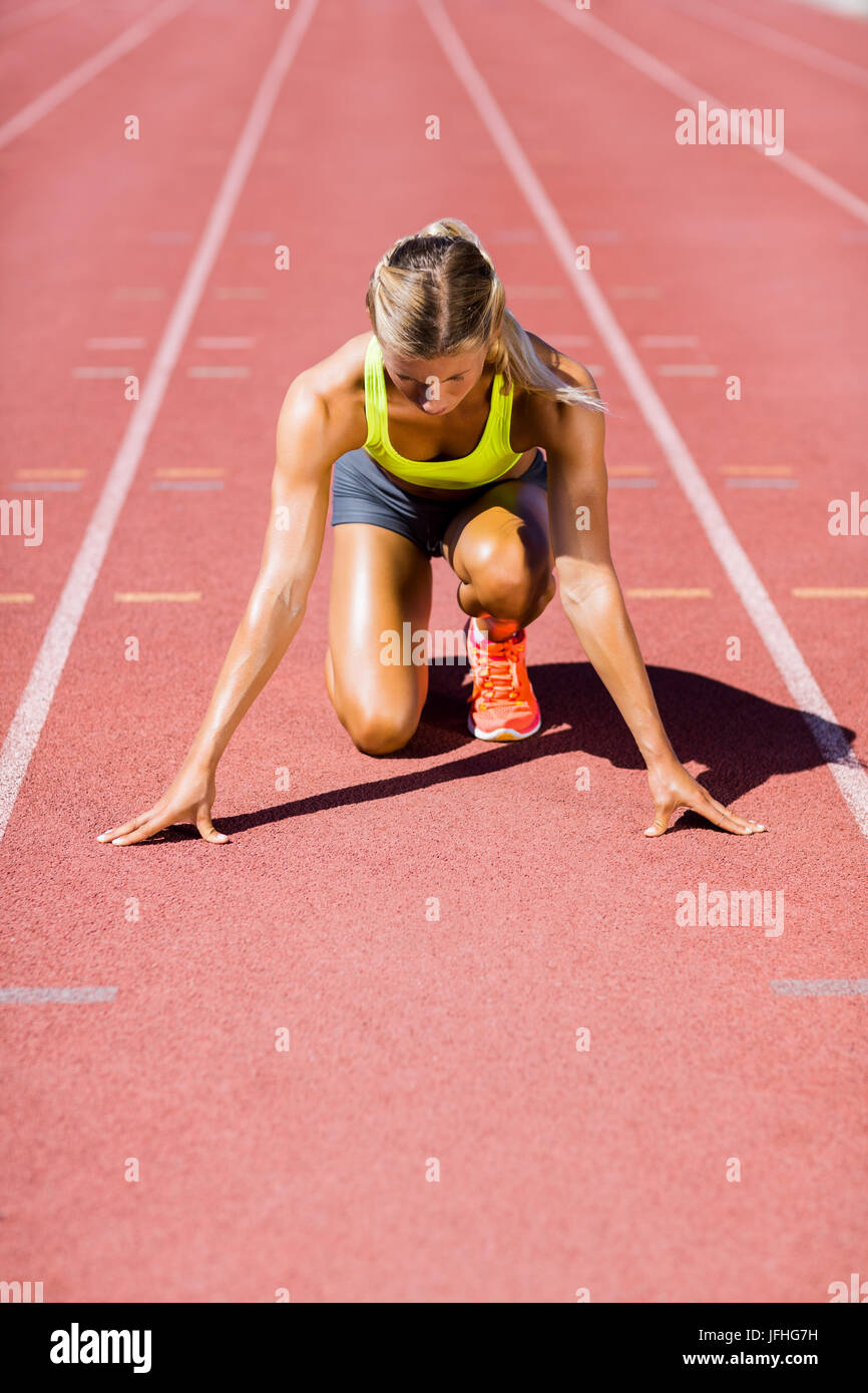 Atleta Femenina listo para correr en la pista de atletismo Foto de stock