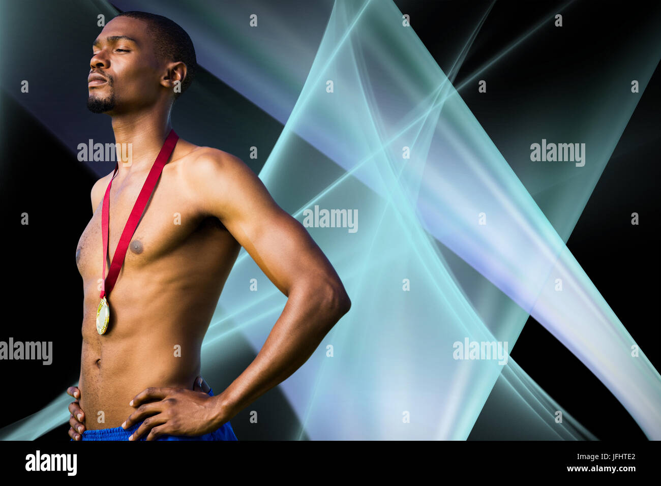 Athletic hombre posando con la medalla de oro contra el fondo negro Foto de stock