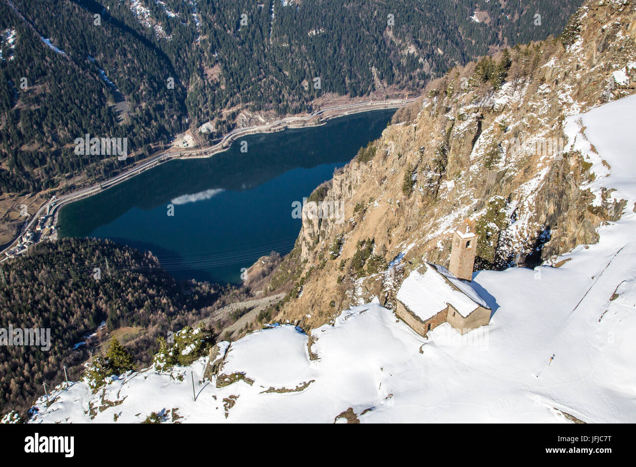 Vista aérea de la iglesia de San Romerio en invierno, el cual fue construido verticalmente hasta el lago de Poschiavo, Alp San Romerio, Brusio, valle de Poschiavo, Cantón Grigioni, Suiza Foto de stock