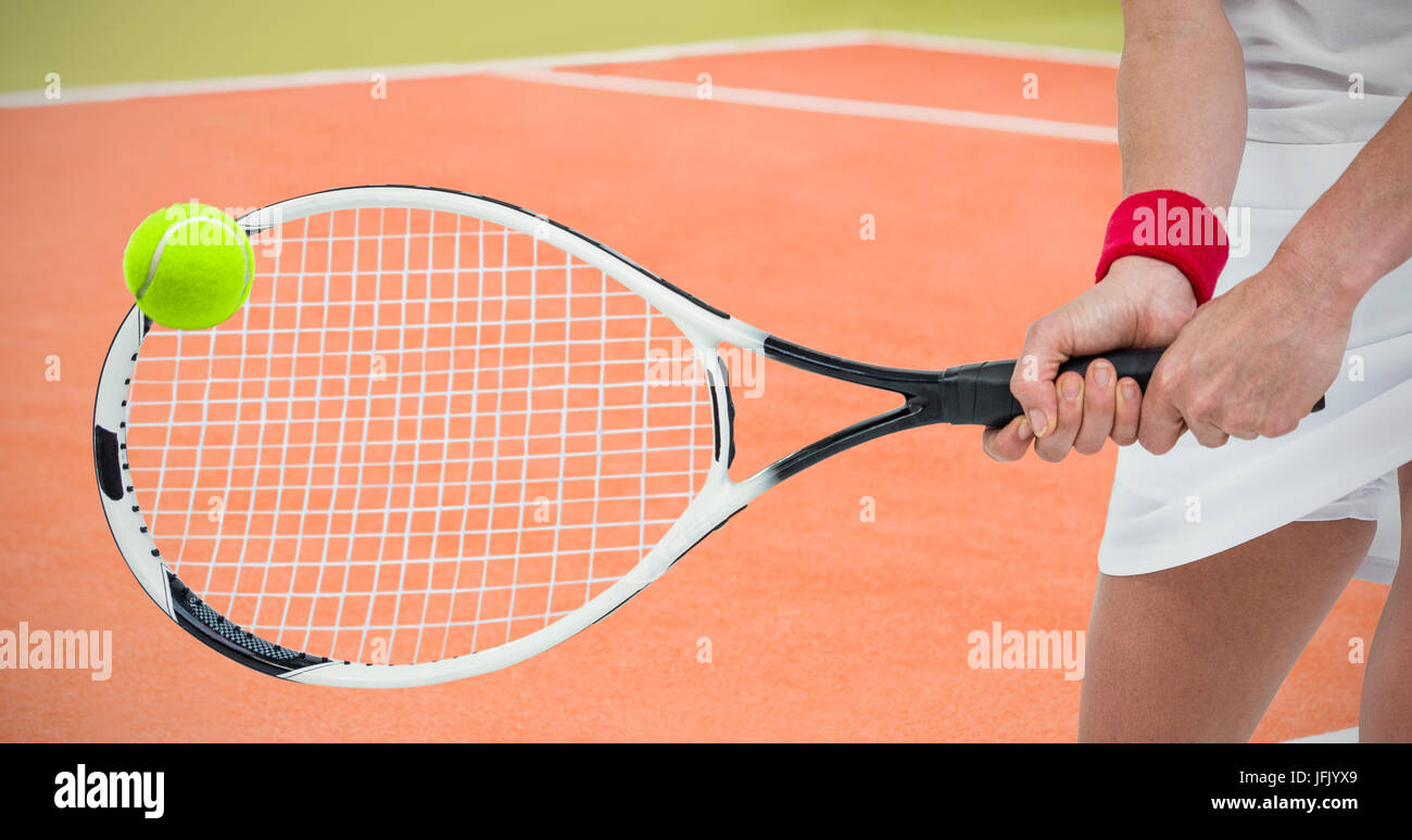 Atleta jugando con una raqueta de tenis contra la imagen compuesta de cancha de tenis Foto de stock