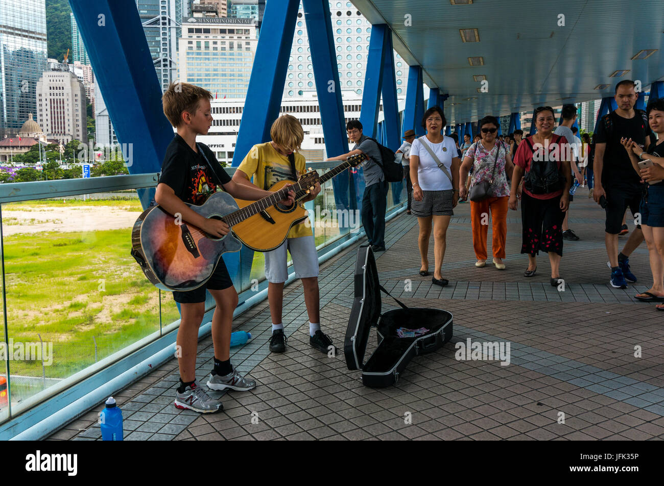 Los jóvenes caucásicos músicos callejeros, músicos callejeros, tocando guitarras en Hong Kong, China Foto de stock