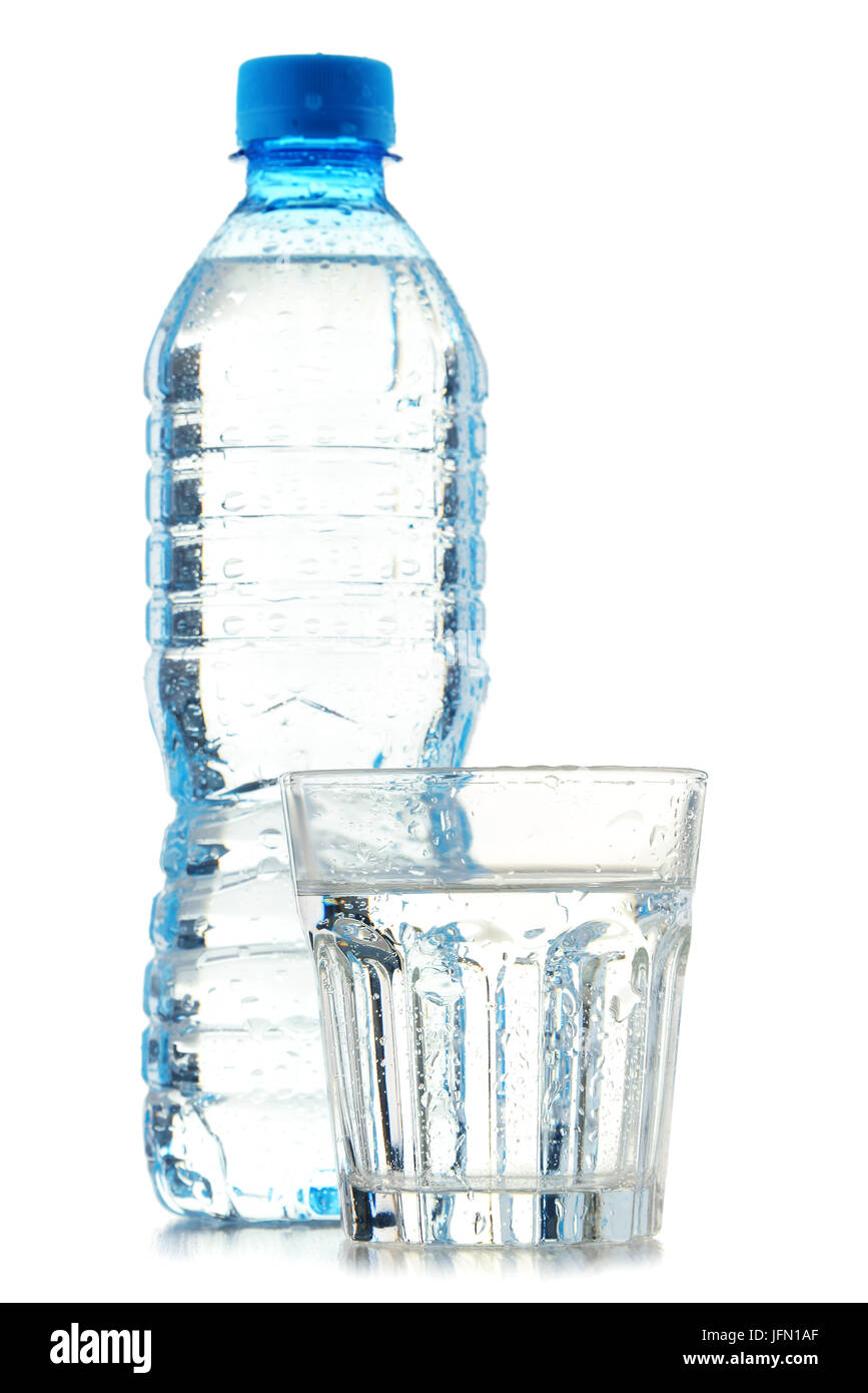 Botella y vaso de agua mineral aislado sobre fondo blanco. Foto de stock