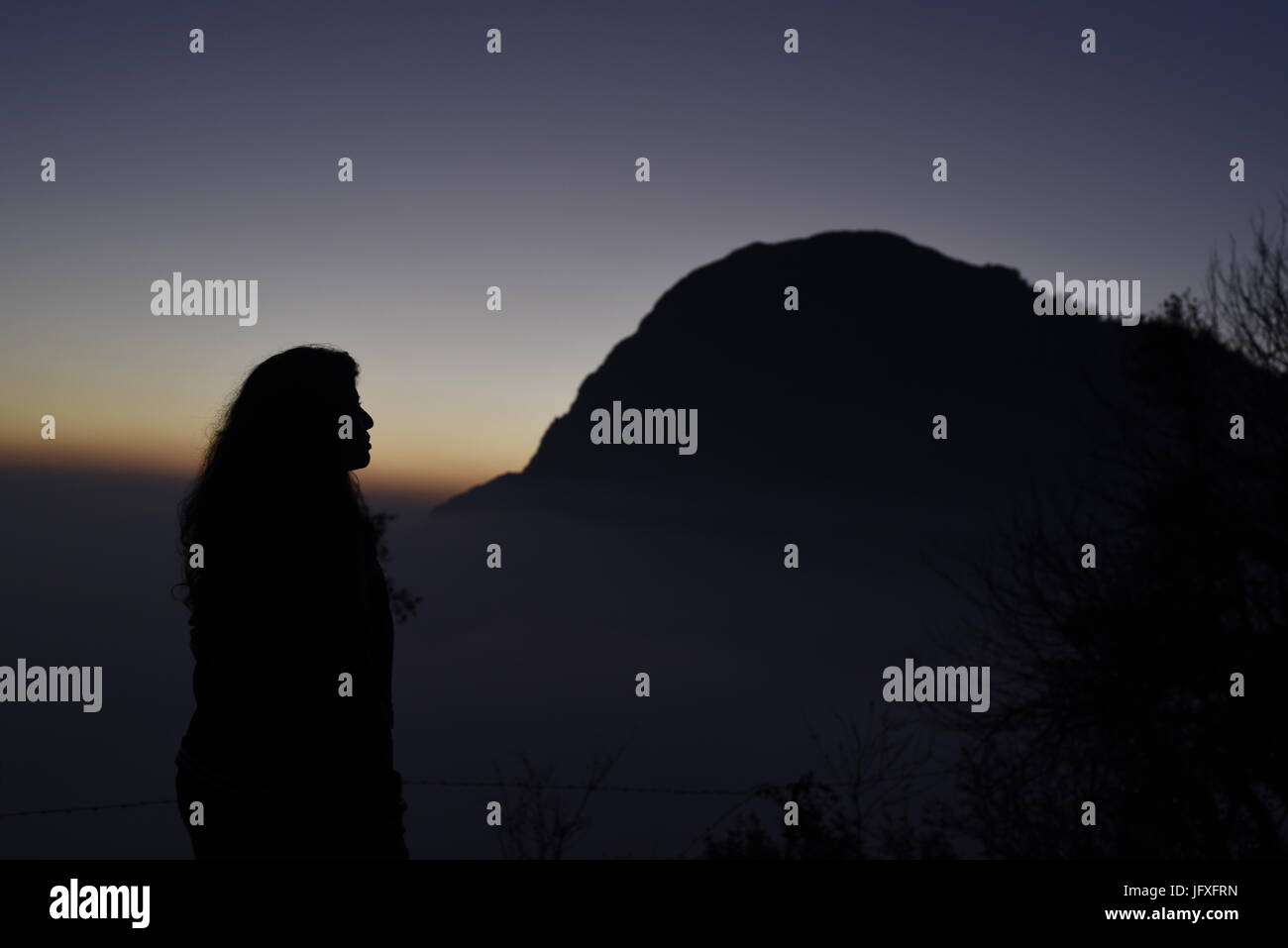 Scenic hermosa puesta de sol vista desde el punto más alto de la montaña naranja azul cielo en la oscuridad a Dhanaulti, Uttrakhand, India, Asia Foto de stock