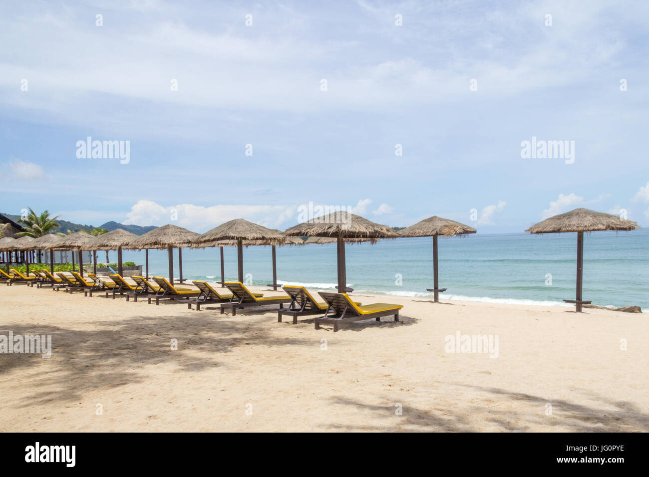 Sombrillas de paja y reposeras en la playa de Bang Tao Beach, Phuket,  Tailandia Fotografía de stock - Alamy