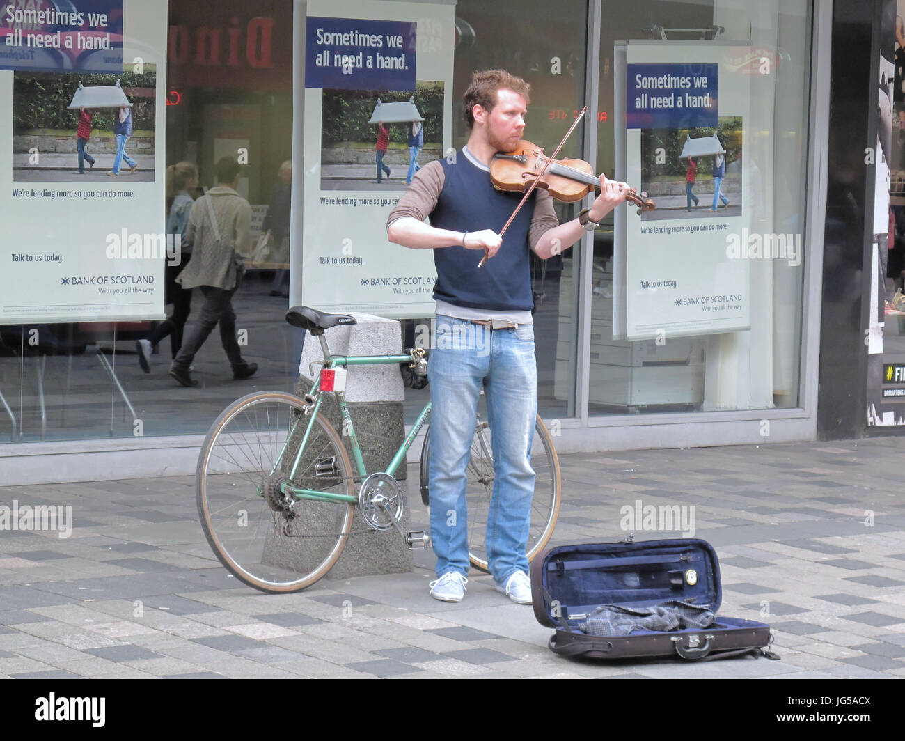 Artistas de la calle músico ejecutante utiliza el violín o un violín con bicicleta y caso por dinero Foto de stock