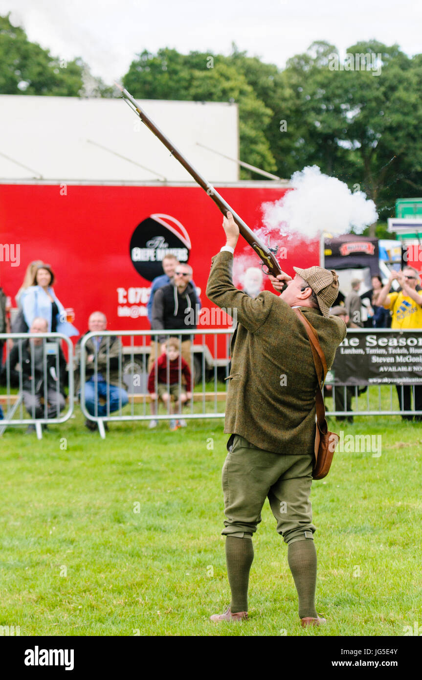 Un hombre vestido de verde irlandés chaqueta tweed deerstalker Lovat,  sombrero, chaleco y pantalones, dispara su rifle flintlock Fotografía de  stock - Alamy