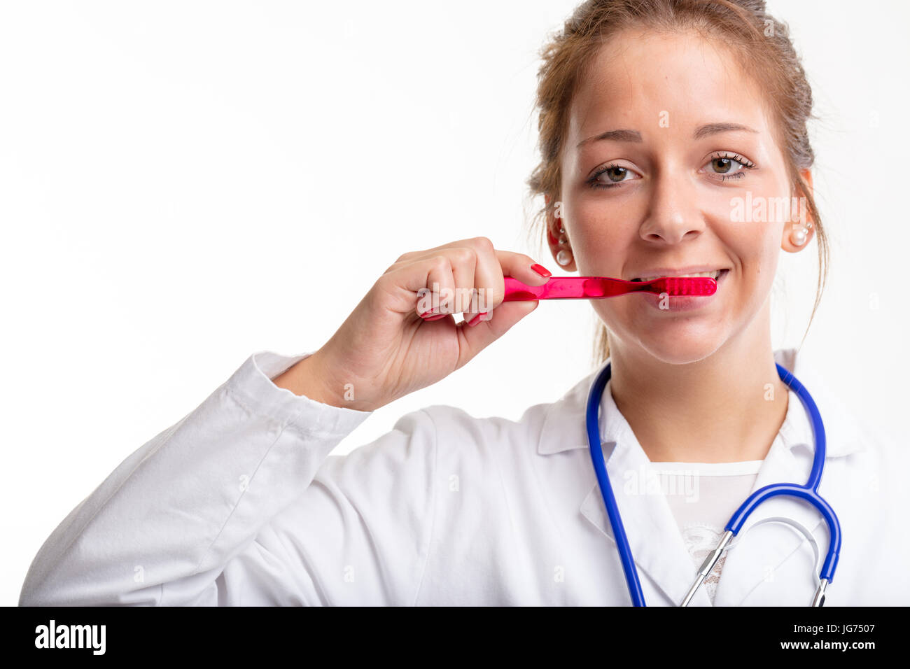 Joven enfermera o médico dental El cepillado de los dientes con un cepillo de plástico rojo en una higiene bucal y odontología concepto aislado en blanco Foto de stock