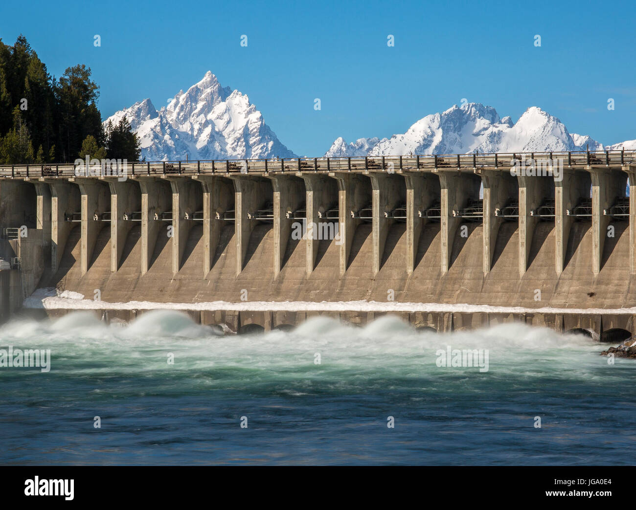 Jackson Lake Dam fluyendo agua rápidamente, a fin de vaciar el lago que es alimentado por el Río Snake Foto de stock