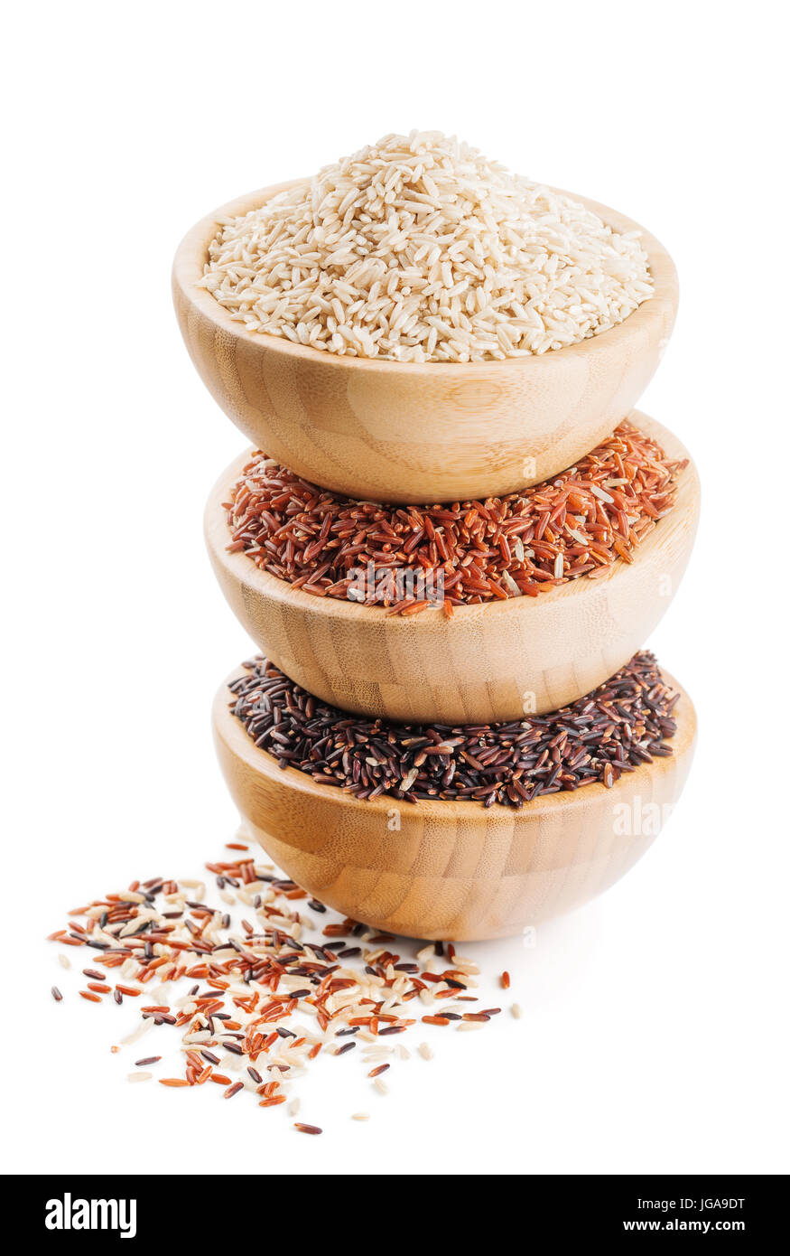 Diferentes tipos de arroz en cuencos de madera aislado en blanco Foto de stock