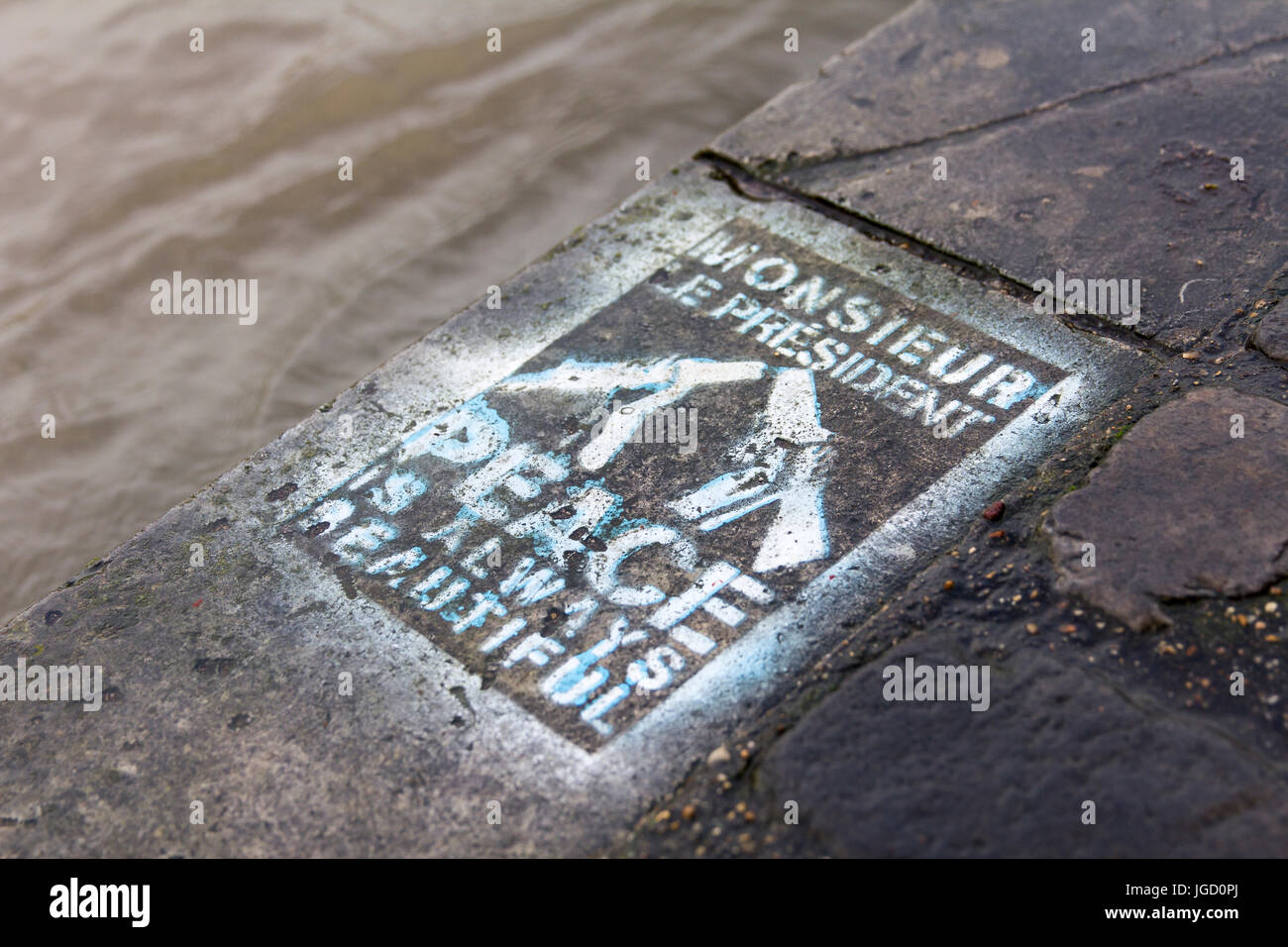 En París, en el muelle del río Sena, una etiqueta en el pavimento: Monsieur le président, la paz siempre es hermoso. Foto de stock