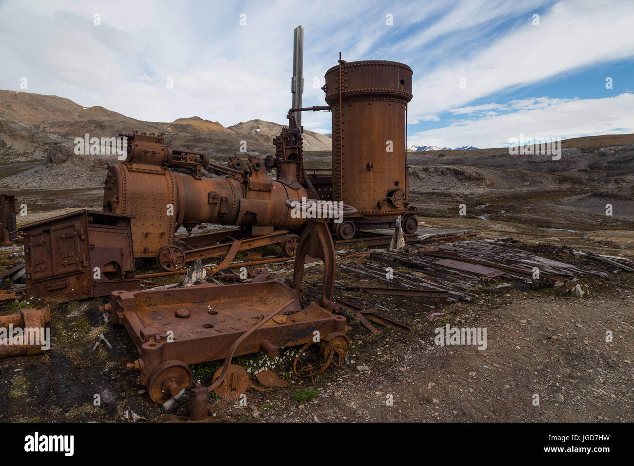 La oxidación restos de una gran locomotora de vapor permanece en posición encima de las fundaciones de madera de una choza abandonada en New London en Spitzbergen Foto de stock