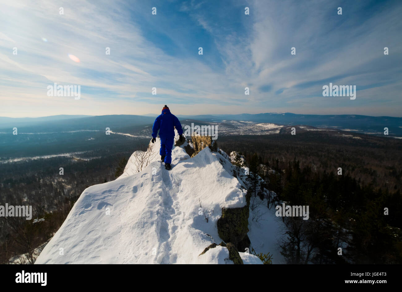 Hombre caucásico senderismo en la cima de la montaña en invierno Foto de stock
