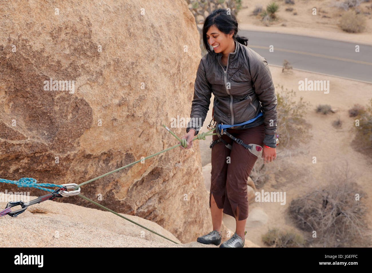 Mujer joven del sur asiático escaladas en roca el desierto en una pared muy difícil Foto de stock