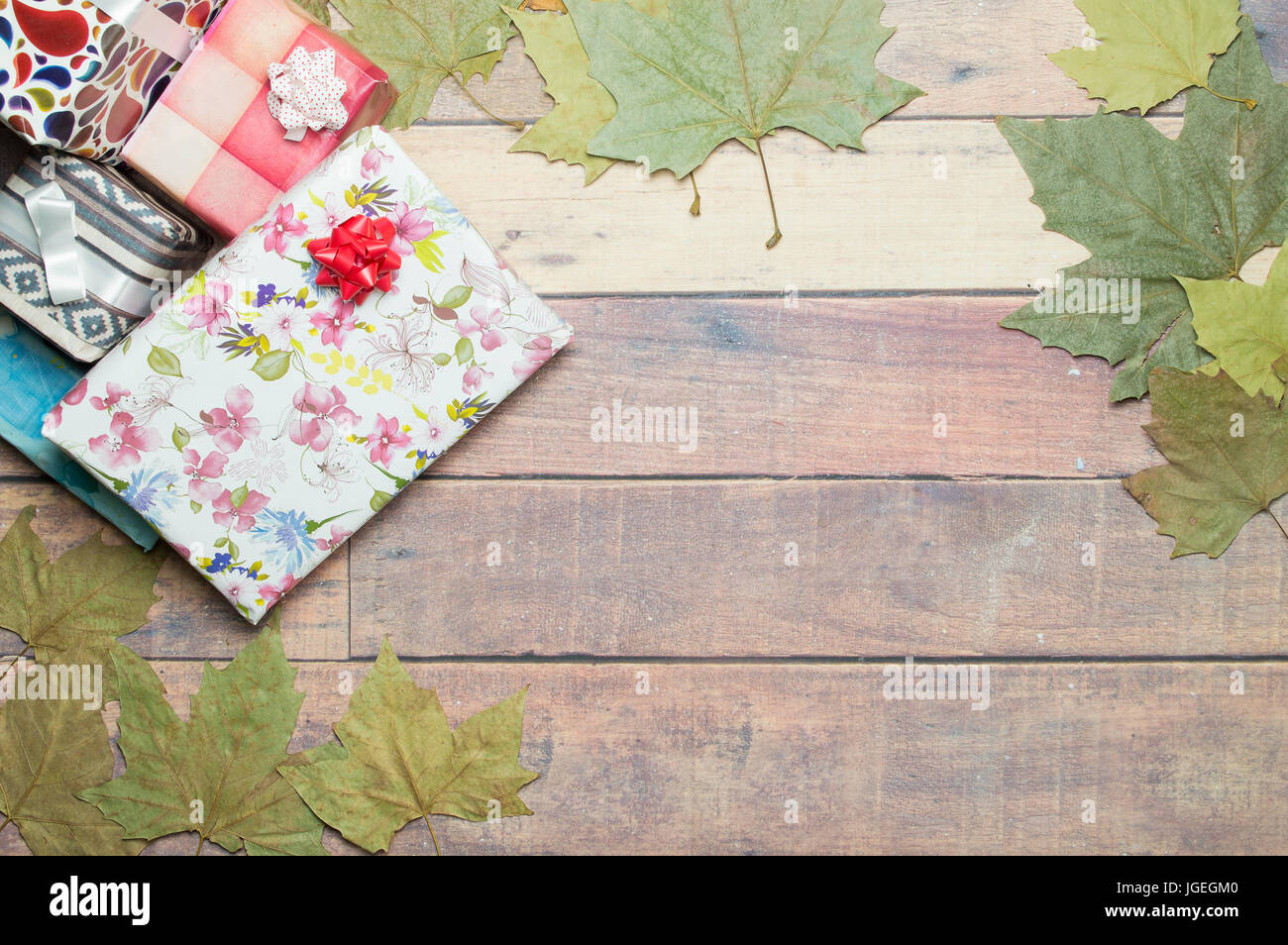 Regalos y hojas de otoño sobre la mesa de madera para escribir una dedicatoria Foto de stock