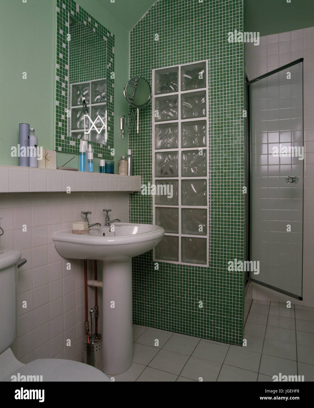 Baño pequeño con ducha formada de mosaico y pared de ladrillos de vidrio  Fotografía de stock - Alamy