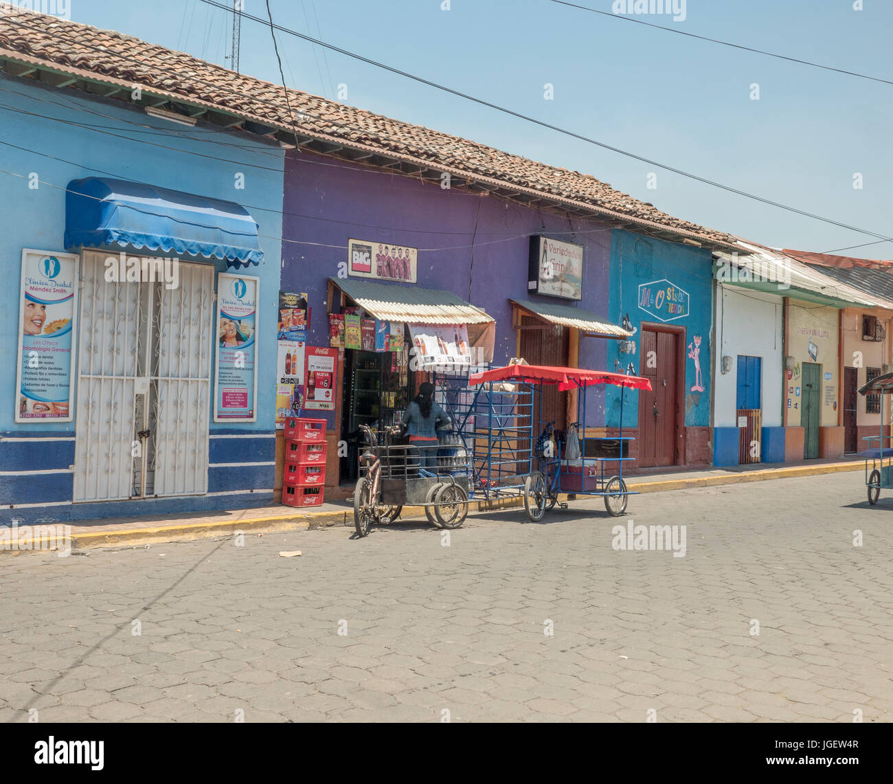 Taxi Pedal estacionado afuera de una pequeña tienda de venta de Coca Cola en antiguos edificios coloniales en Corinto Nicaragua Foto de stock