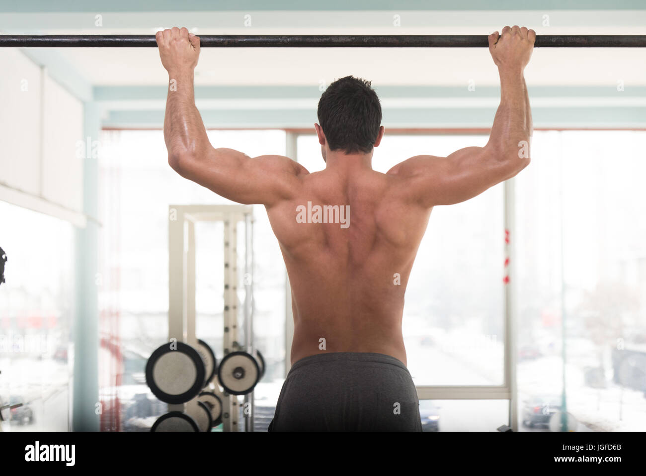 Hombre deportista haciendo tirar ups - Chin-Ups en el gimnasio. Foto de stock