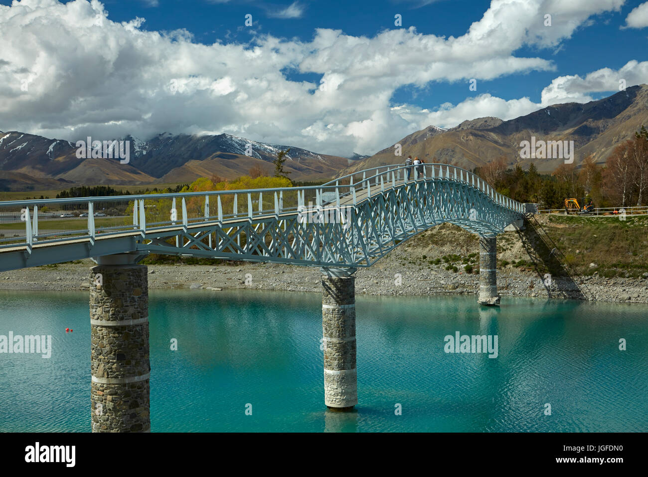 Los turistas de un puente peatonal sobre el Lago Tekapo salida a la Iglesia del Buen Pastor, Mackenzie País, Canterbury, Isla del Sur, Nueva Zelanda Foto de stock
