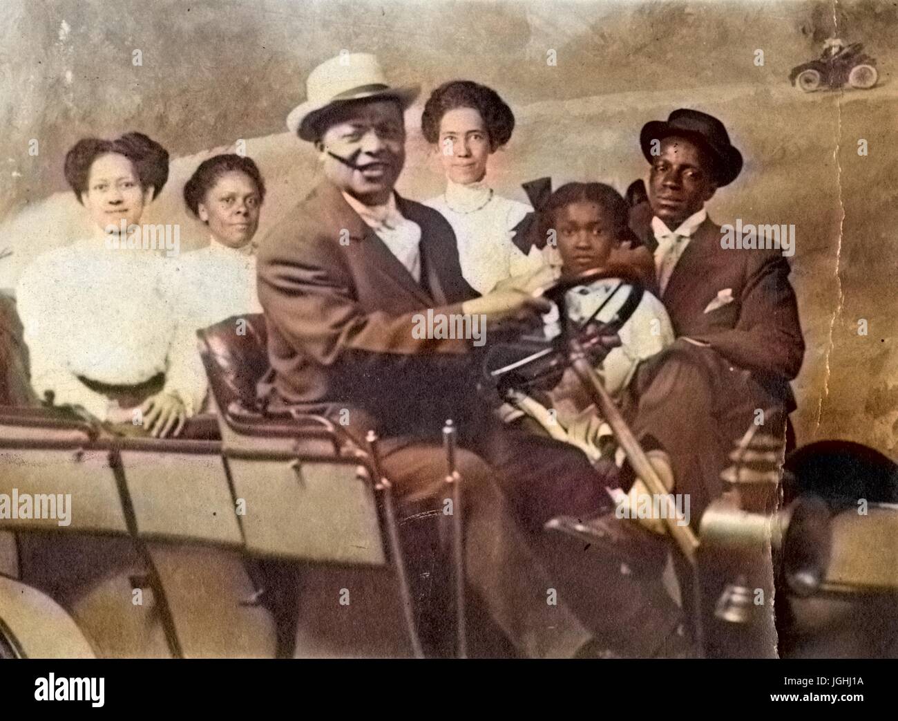 Retrato de familia afroestadounidense, con automóvil, en el estudio fotográfico, 1930. Nota: la imagen ha sido coloreada digitalmente mediante un proceso moderno. Los colores pueden no ser exactos del período. Foto de stock