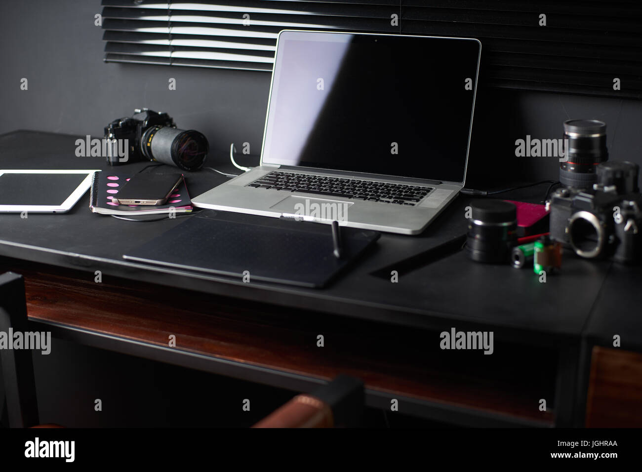 Espacio de trabajo en el cuadro negro de un fotógrafo o diseñador con laptop , retro , cámara elegante studio Inicio Concepto de hipster . Enfoque seleccionado. Foto de stock