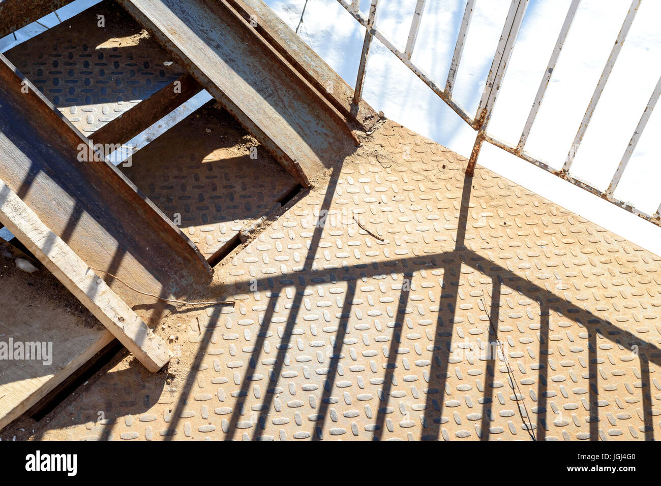 Las sombras de los antiguos pasamanos metálicos fundidos en la luz del día fuerte Foto de stock