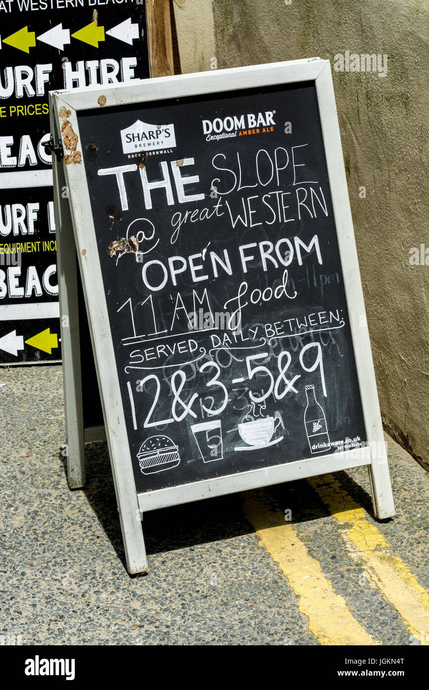 Un bastidor en cartel en los horarios de apertura de un negocio de hostelería en Newquay, Cornwall. Foto de stock