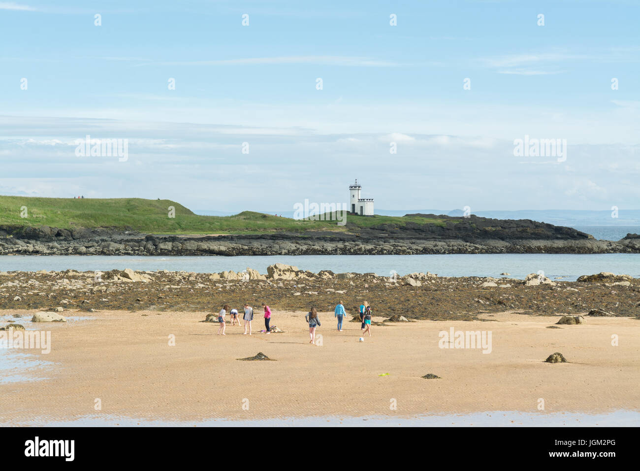 Niños jugando en la playa arenosa de la Bahía Escocesa en Ruby, Elie woodhaven, Fife, Escocia, Reino Unido Foto de stock