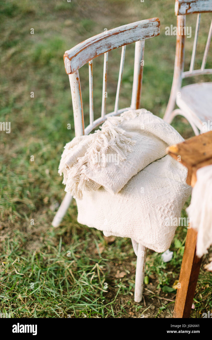 Picnic, mobiliario, decoración concepto - vintage sillas antiguas de madera  con alfombras situadas en el picnic de verano cerca de una mesa de madera  en un césped natural Fotografía de stock - Alamy