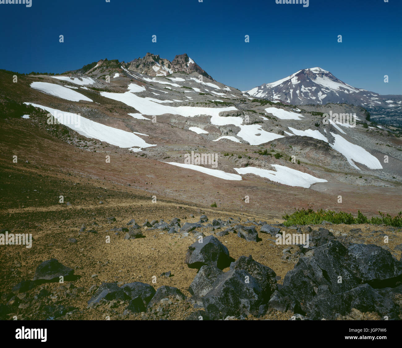 USA, Oregon, Deschutes National Forest, Tres Hermanas Desierto, roto arriba y Hermana Sur con nieve persistente del invierno anterior, vista noroeste Foto de stock