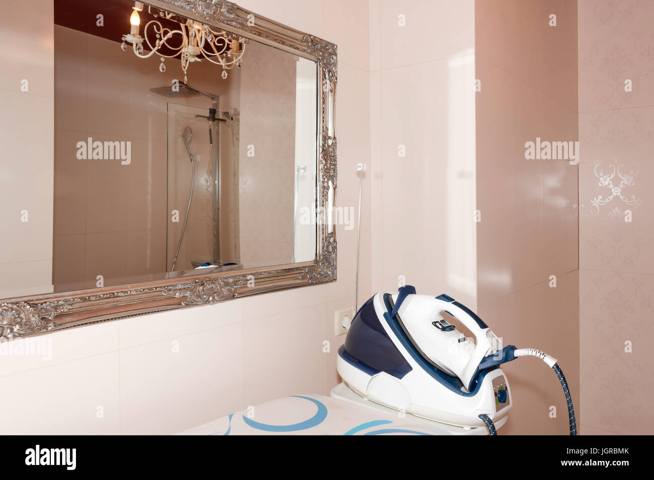 Plancha de vapor, la vaporera con tabla de planchar en el cuarto de baño  moderno interior Fotografía de stock - Alamy