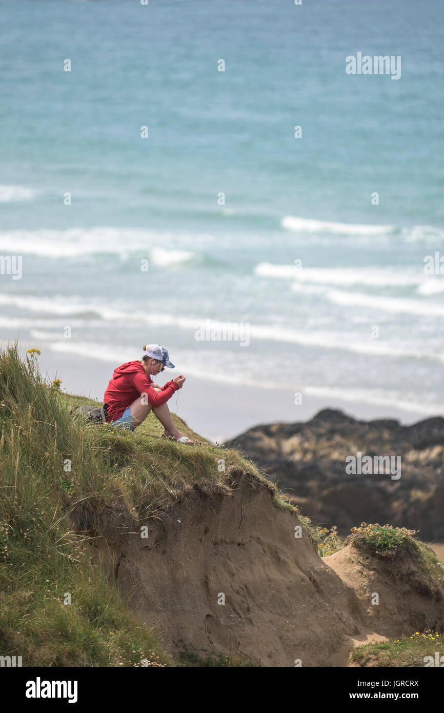 Una joven mujer de relax en el sol en el cabecero en Newquay, Cornwall. Foto de stock