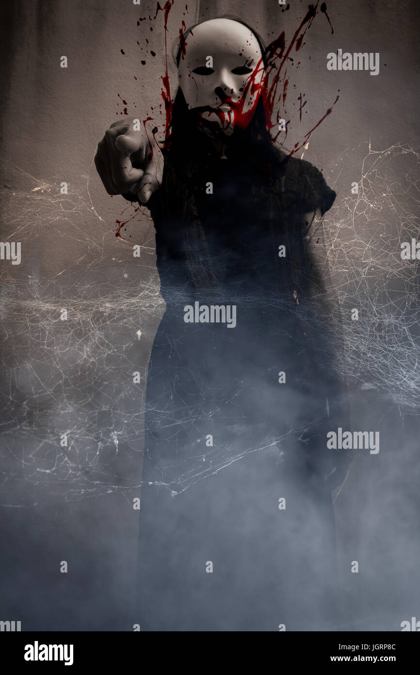 Misteriosa mujer en negro vestidos de máscara blanca llena de sangre dedo  adelante,Scary fondo de portada del libro Fotografía de stock - Alamy