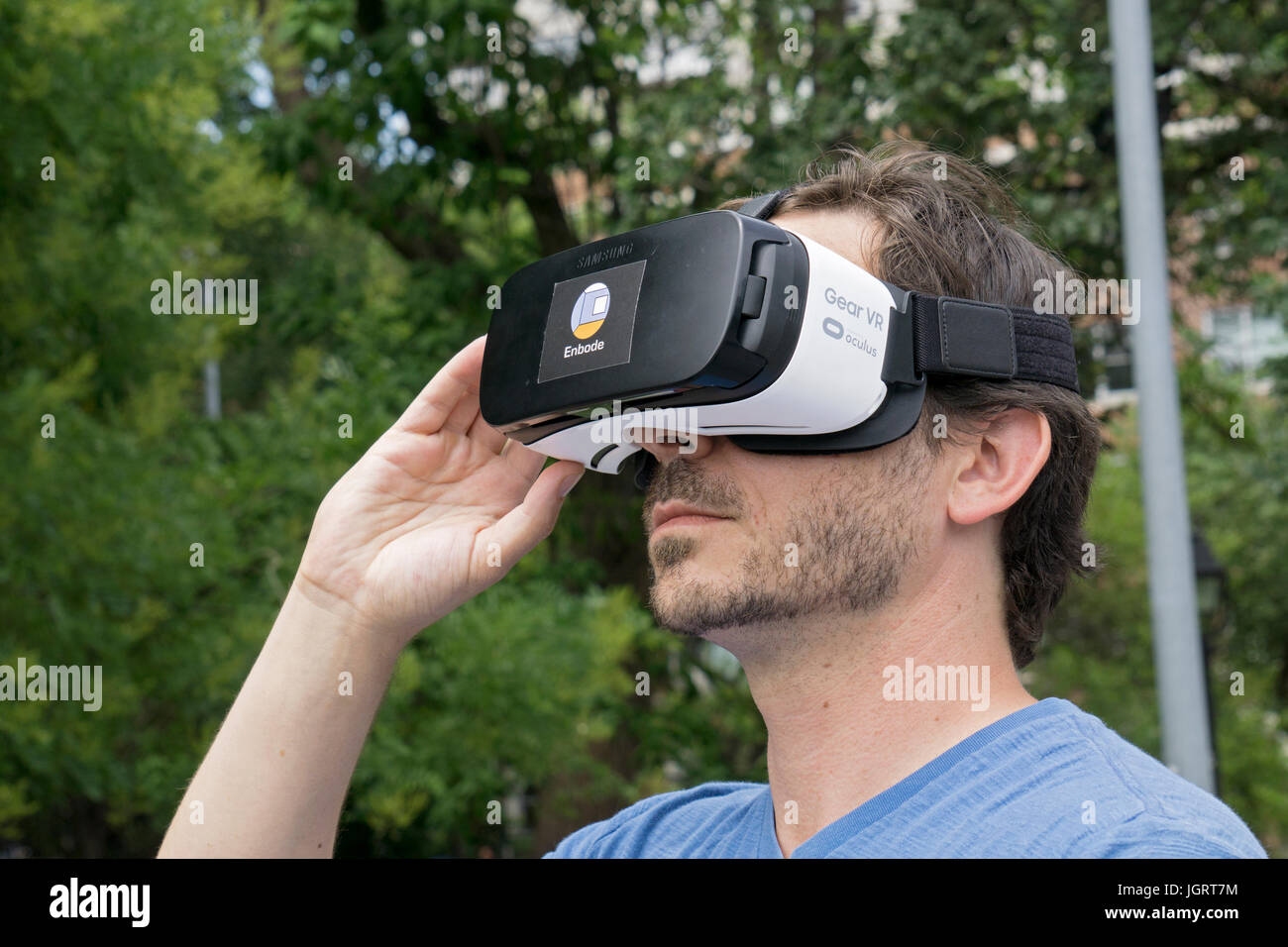 Un agente inmobiliario buscando un engranaje Samsung VR casco de realidad virtual con el nuevo software para mostrar apartamentos con realidad virtual tours. Foto de stock