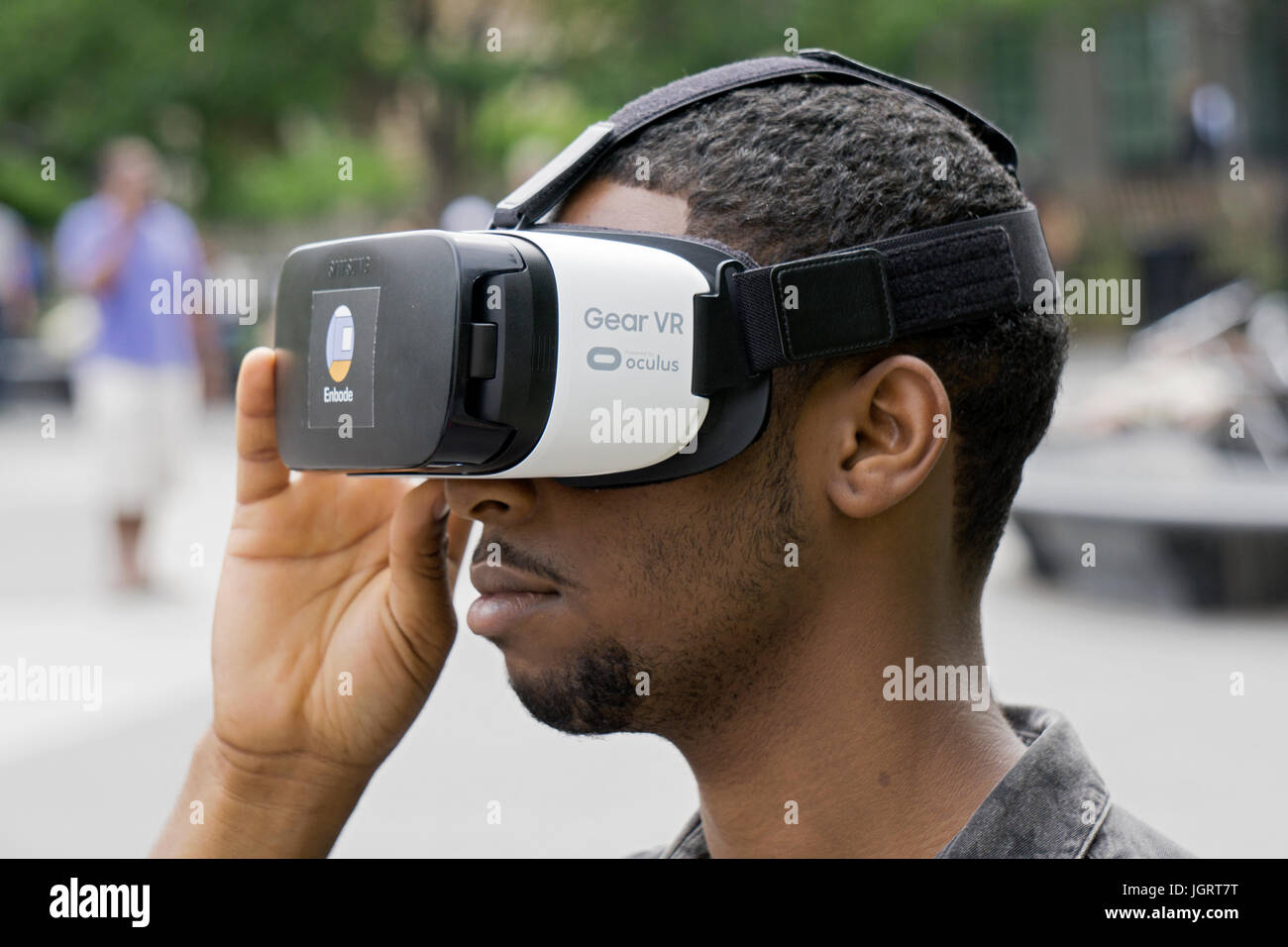 Un agente inmobiliario buscando un engranaje Samsung VR casco de realidad virtual con el nuevo software para mostrar apartamentos con realidad virtual tours. Foto de stock
