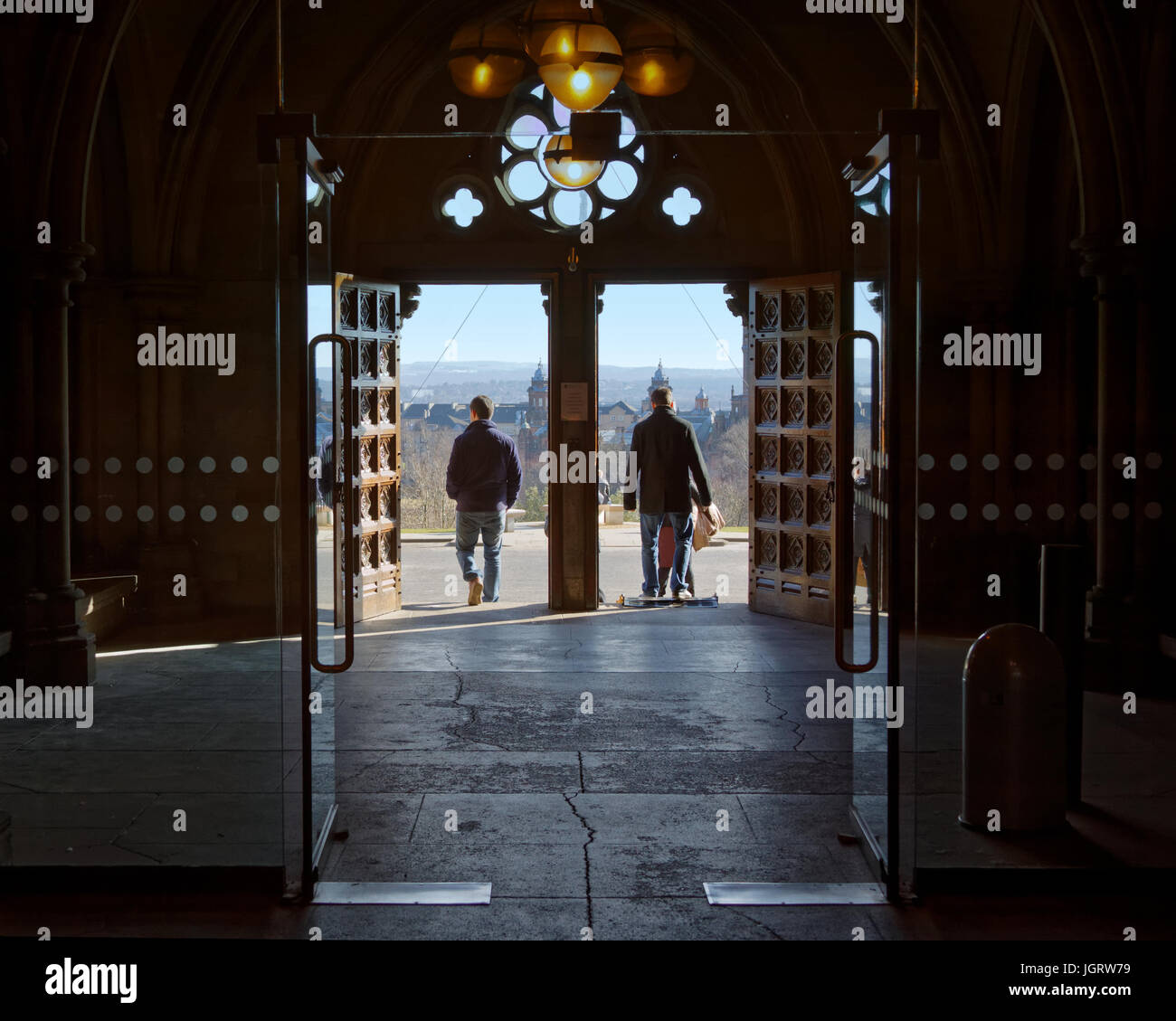 La Universidad de Glasgow, Escocia, Reino Unido, vista interior entrada salida al frente y un mástil siluetas de estudiantes Foto de stock
