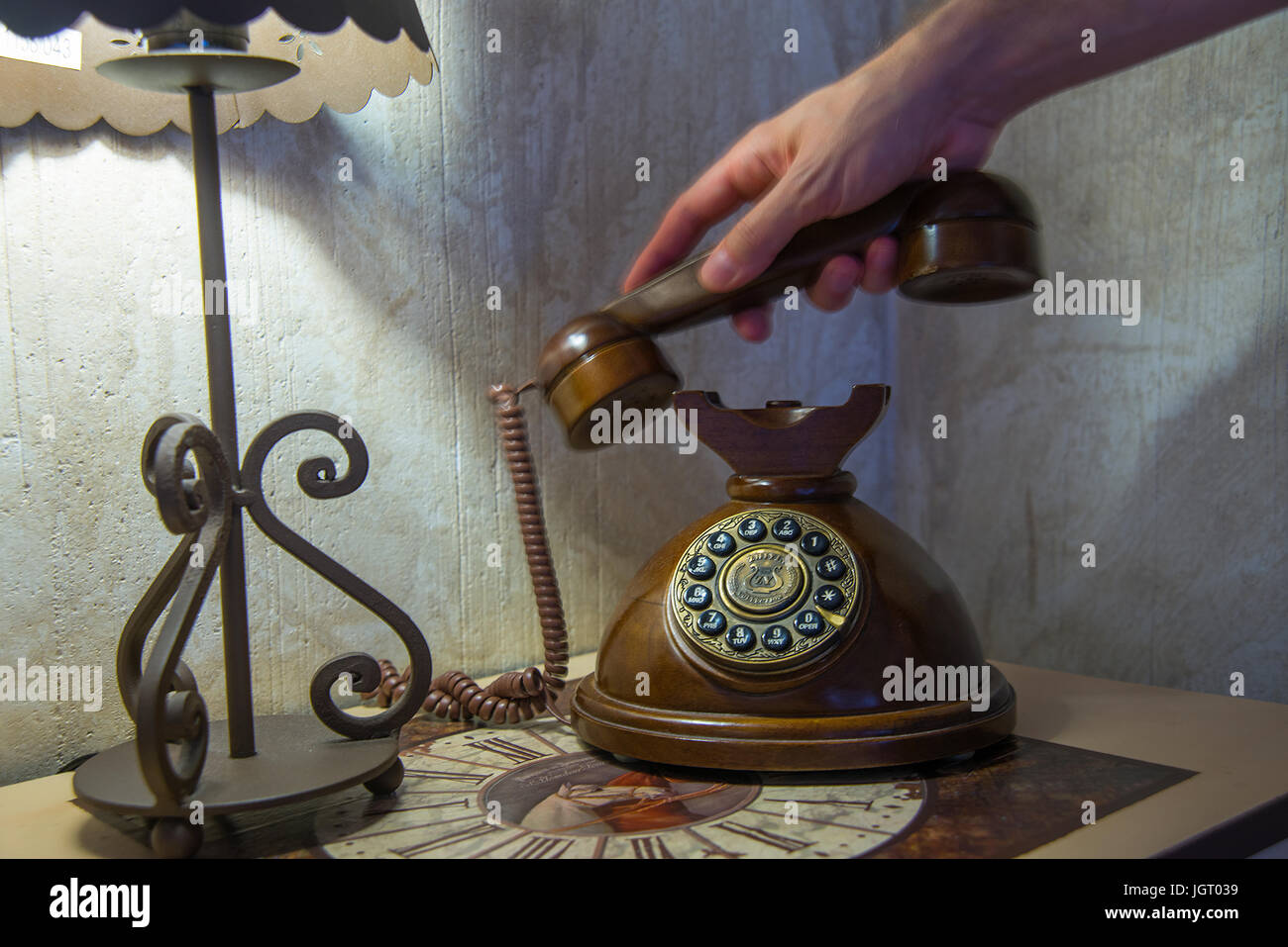 La mano del hombre descolgar el auricular de un teléfono antiguo. Foto de stock
