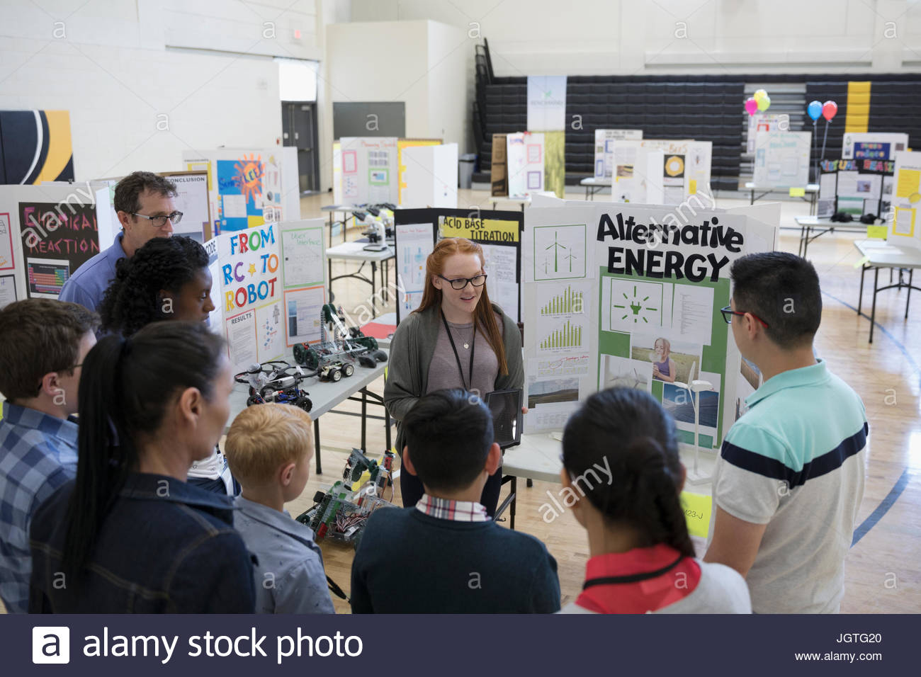 Los estudiantes de escuela intermedia y padres viendo la presentación de energía alternativa en la feria de ciencias Foto de stock