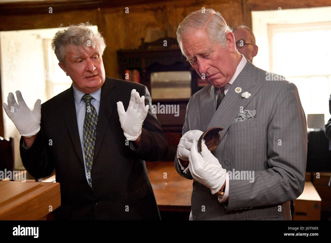 El Príncipe de Gales, está unido por el Profesor David Austin (izquierda) como él maneja la Copa Nanteos durante una visita a la Strata Florida sitio en Ceredigion, Gales. Foto de stock