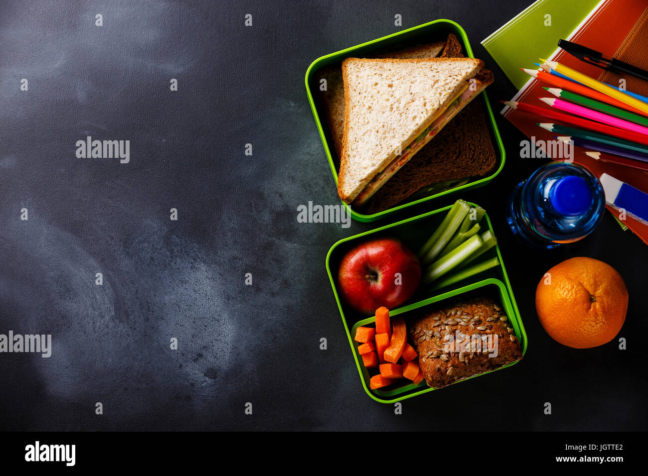 Comida para llevar Lunch box con sandwiches y verduras, botella de agua y suministros escolares espacio de copia Foto de stock