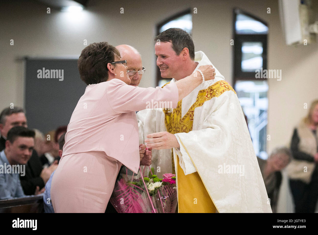 El ex jugador del Manchester United Philip Mulryne dando su madre Sally y  el padre Tony una boutique de flores durante su primera misa en la iglesia  San Oliver Plunkett en el