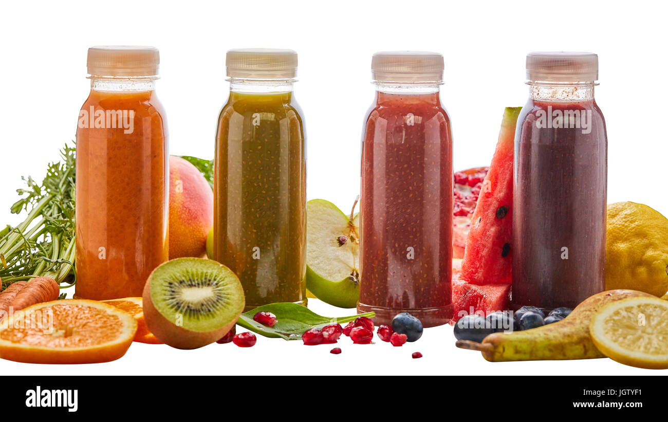Selección de diferentes energizantes licuados de frutas en cuatro botellas rodeado por ingredientes frescos con pera, naranja, sandía, pomelo, kiwi, ma Foto de stock