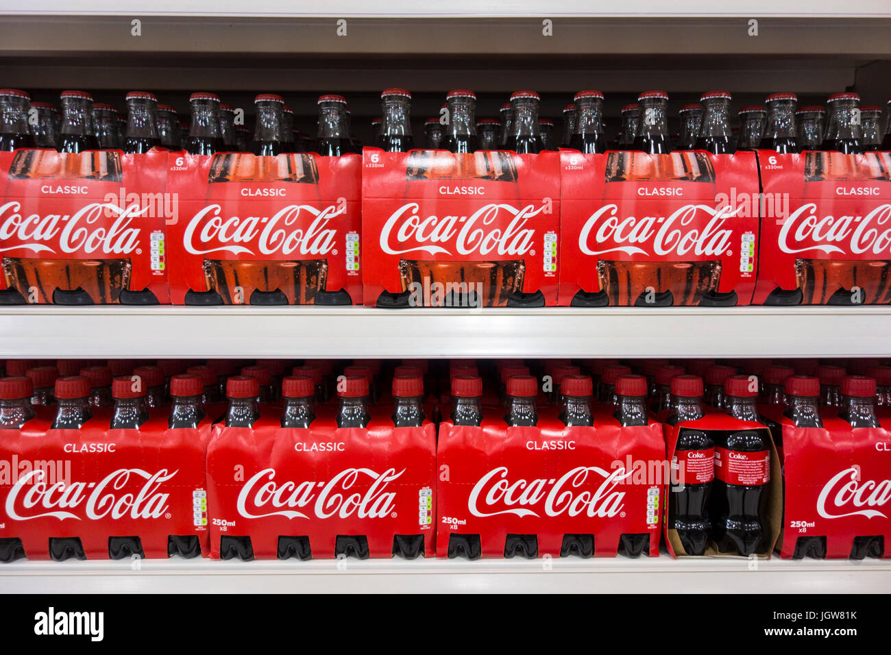 Multi-pack de botellas de vidrio y plástico de Coca Cola / coque para la venta en un supermercado en el REINO UNIDO Foto de stock