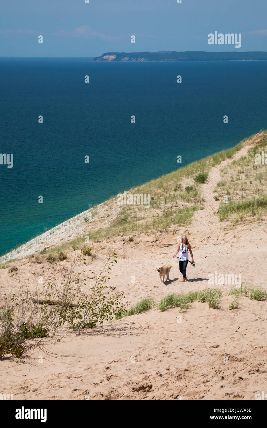 Imperio, Michigan - una mujer y su perro a pasear a lo largo de una duna de arena sobre el Lago Michigan en Sleeping Bear Dunes National Lakeshore. Foto de stock