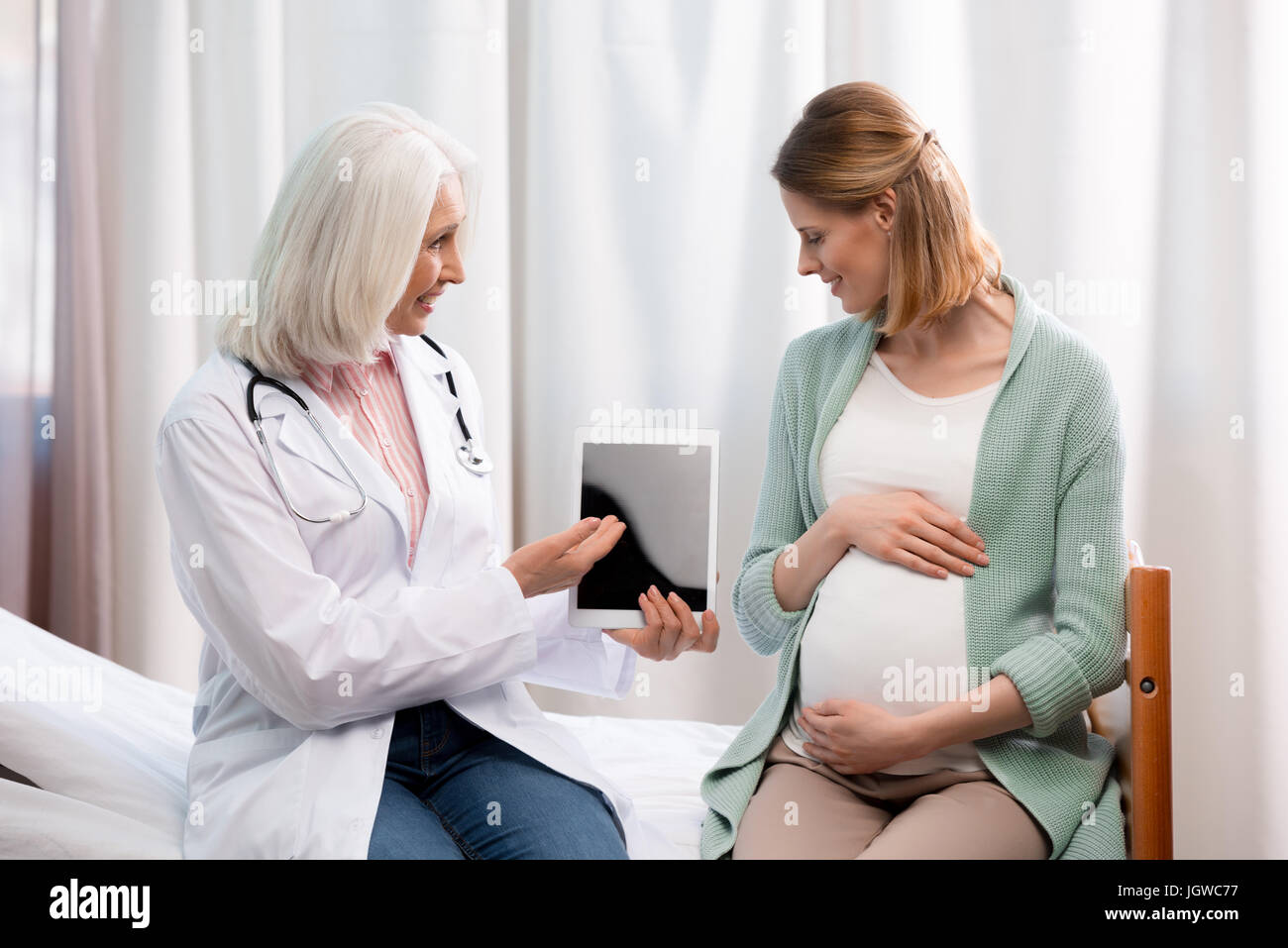 Doctor mostrando la información del proceso de embarazo de la mujer  embarazada en el hospital Fotografía de stock - Alamy