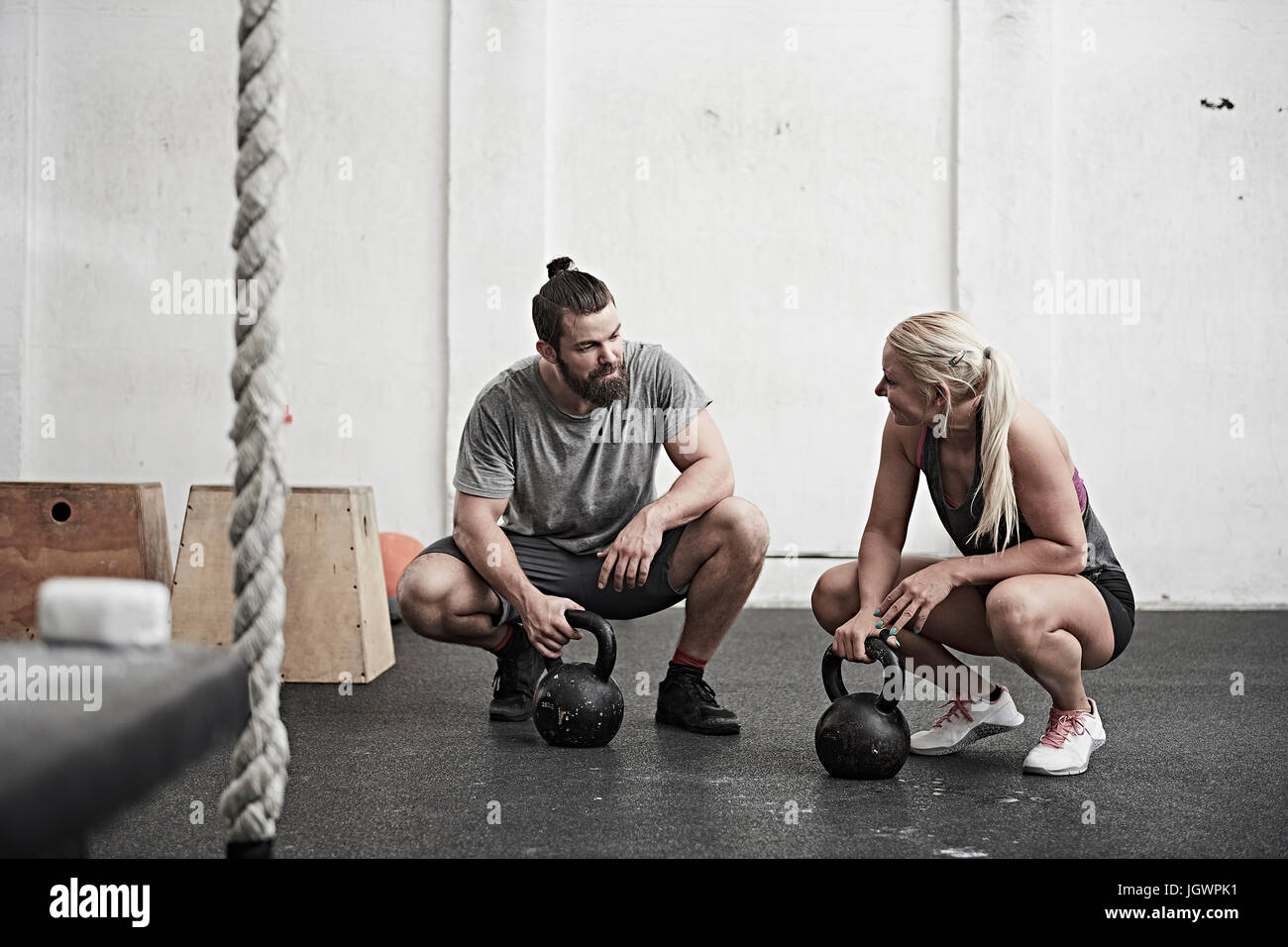 Hombre y mujer fit muscular entrenar con kettle ball en el gimnasio  Fotografía de stock - Alamy