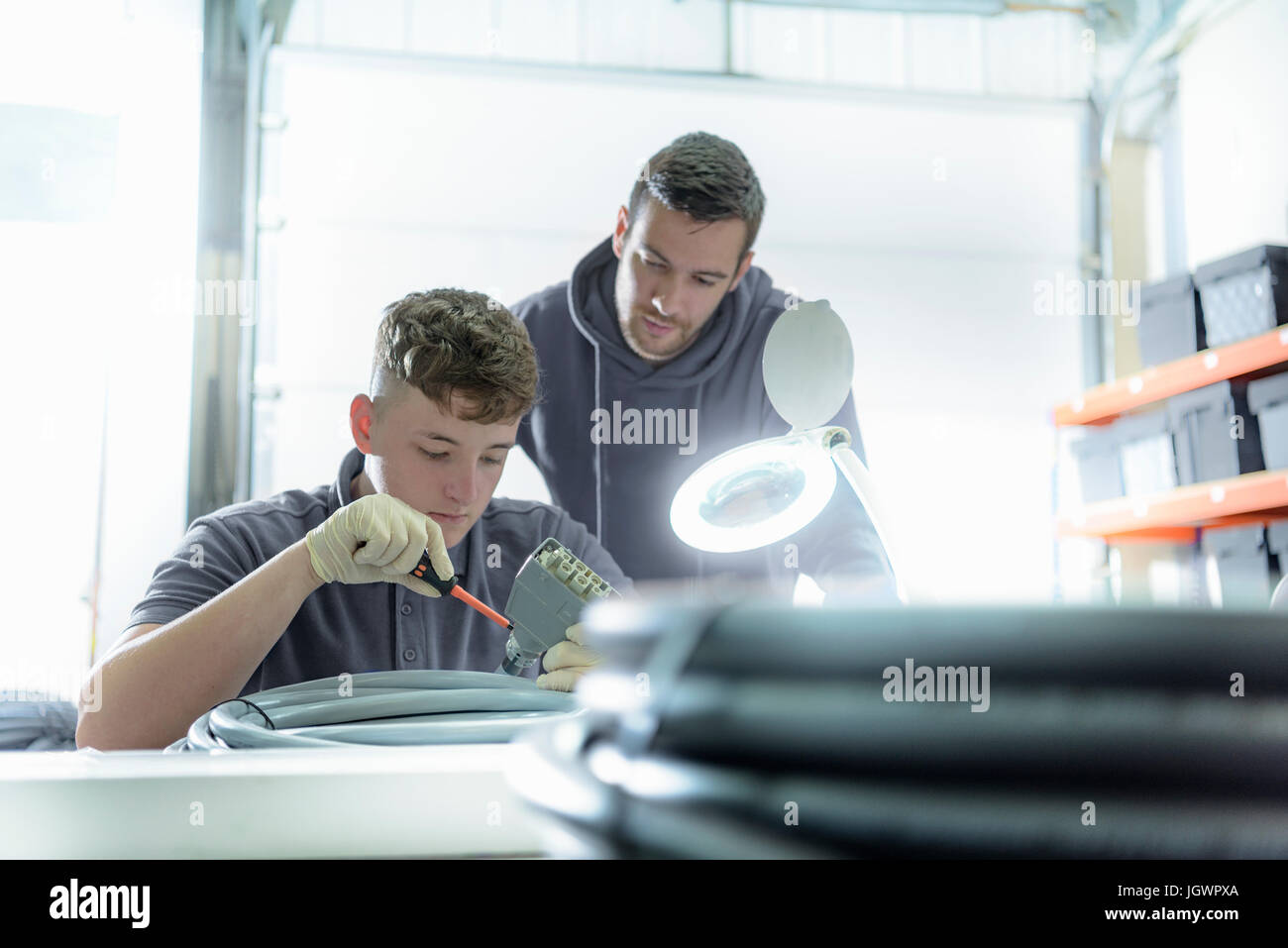 Aprendiz e ingeniero eléctrico mentor en cable de fábrica de acabado Foto de stock