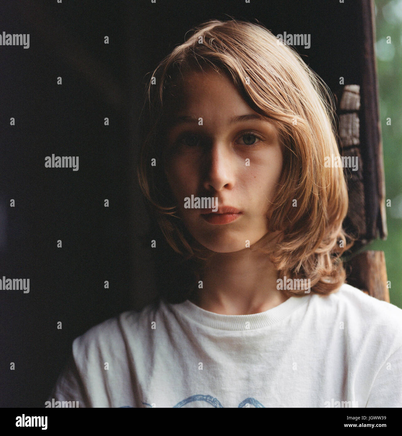 Retrato de niño con pelo largo, pensativo expresión Foto de stock